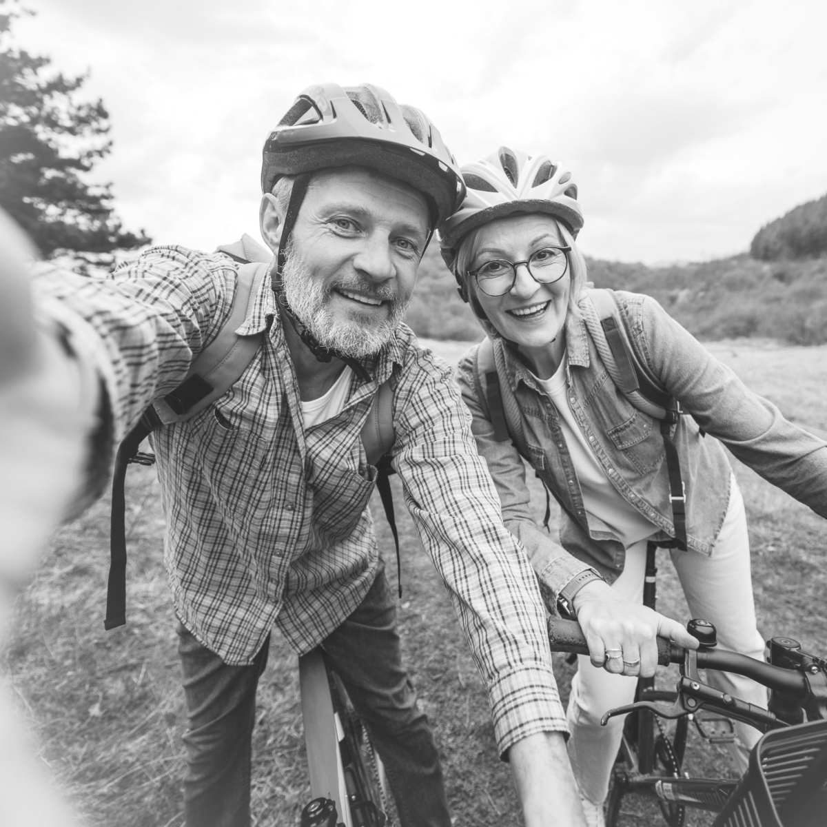 Couple à vélo dans un cadre rond aux bords vaporeux sur fond blanc.